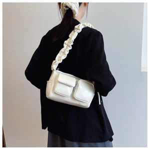 Detail view of white PU leather crossbody bag with scrunchie strap and dual zip pockets