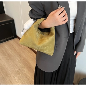 Detail of olive green matte PU hobo bag with zip closure and white pompom charm