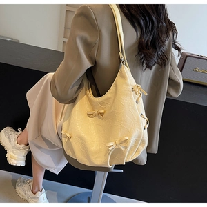 Détail du sac à bandoulière en PU plissé jaune crème avec des nœuds décoratifs