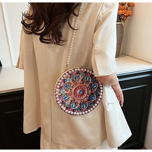 Detail of round cotton linen crossbody bag with mandala pattern and pearl strap details