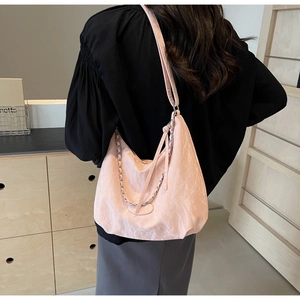 Pink hobo shoulder bag with textured fabric, silver chain detail, and a long strap