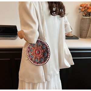 Detailed view of round crossbody bag with colorful mandala patterns and pearl trim decoration