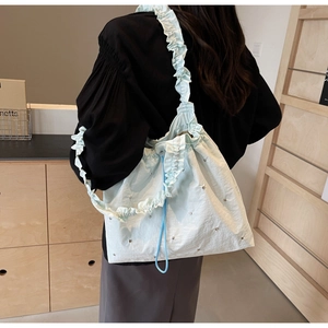 Detailed back view of a light green pleated fabric shoulder bag with ruffles and metallic dots
