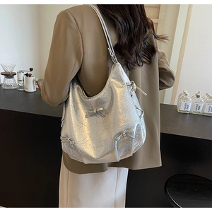 Detailed shot of silver pleated leather shoulder bag with cute ribbon bow accents