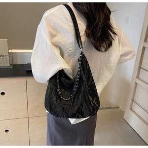 Detail view of black pleated PU leather hobo bag featuring a stylish silver metal chain strap