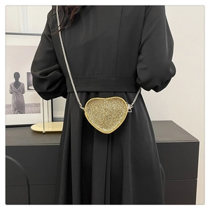 Close-up of a heart-shaped golden rhinestone mini crossbody bag with a metal chain