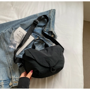 Minimalist black fabric crossbody bag with adjustable wide strap and half-moon design
