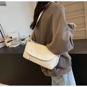 Cremeweiße Crossbody-Tasche aus Stoff an der Schulter für Größenreferenz gezeigt