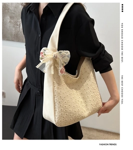 Detail of floral lace embroidery and large ribbon bow on beige canvas handbag