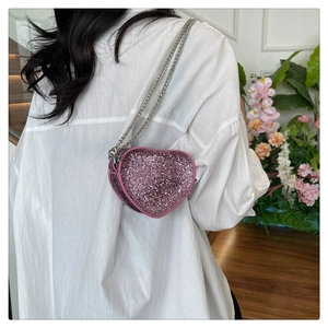 Detail of pink rhinestone heart-shaped mini bag with silver chain straps and zipper