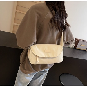 Detailansicht einer cremefarbenen Umhängetasche an einem Model im Lifestyle-Ambiente