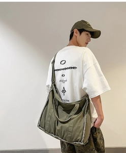 Detail of army green canvas crossbody bag featuring vintage frayed edge design and thick fabric