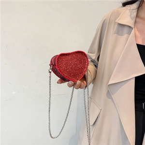 Detailed view of red heart-shaped rhinestone handbag with a silver metal chain strap