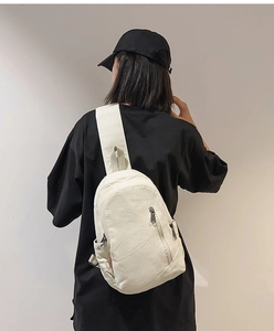 Casual cream canvas crossbody sling bag shown worn on back with minimalist strap design