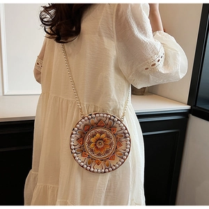 Detail of round cotton linen crossbody bag with floral pattern and pearl trim strap