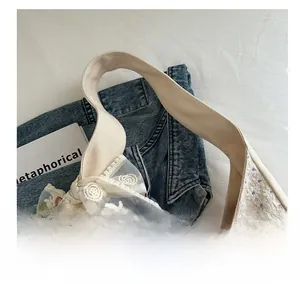 Detailed close-up of cream canvas tote bag featuring floral lace embroidery and bow