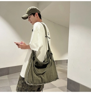 Detail of army green canvas tote bag with distressed edges and adjustable shoulder strap