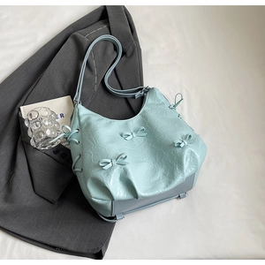 Minimalist light blue PU leather tote bag with bow accents and drawstring texture