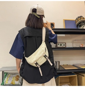 Close-up of minimalist beige canvas chest bag featuring adjustable black buckle straps