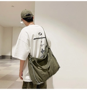 Detailed view of army green canvas tote showing frayed edges and crossbody strap texture