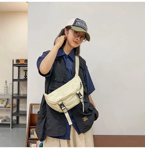 Detail showing the adjustable double buckles and canvas material on the white crossbody bag