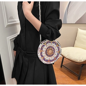 Detailed macro view of purple mandala patterned bag with white pearl trim and chain