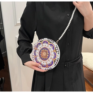 Detailed close-up of mandala patterns and pearl trim on a round crossbody bag