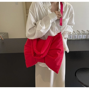 Vue détaillée du grand sac nœud rouge en nylon avec large bandoulière et crochets métal