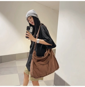 Detail view of brown canvas shoulder bag showing vintage raw edge finish and large capacity
