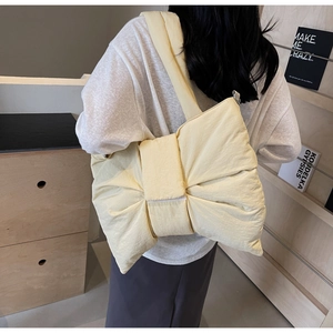 Vue détaillée du sac à bandoulière matelassé crème avec un design de nœud géant
