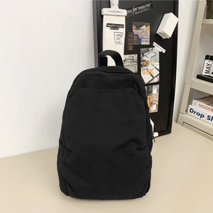 Minimalist black canvas backpack with large main compartment and front zipper pocket