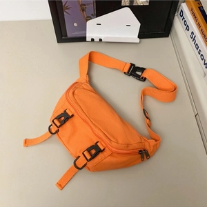 Bright orange canvas crossbody bag with adjustable strap and buckle on beige desk