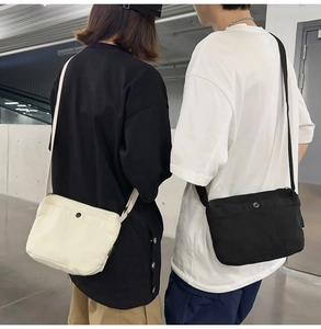 Dual models showing canvas crossbody bags with metal button and woven strap in neutral style