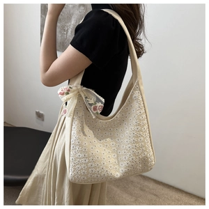 Detail of canvas bag with white floral lace embroidery and pink rose mesh bow accent