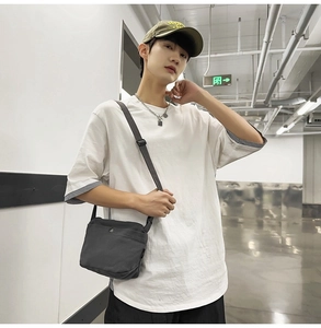 Detail view of the black canvas crossbody bag showing durable texture and strap
