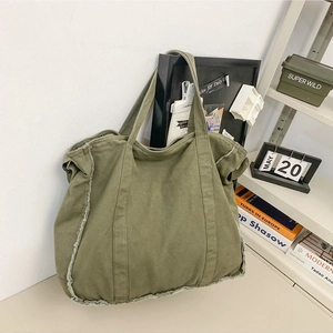 Army green canvas tote bag with fringe details and vintage utilitarian design