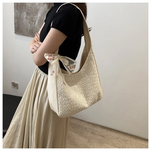 Detail shot of canvas tote with floral lace embroidery and a decorative ribbon bow