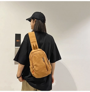 Detailed back view of a khaki canvas crossbody bag with multi-pocket utility design
