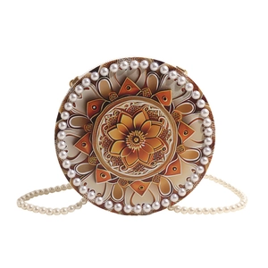 Round evening bag with mandala print, pearl trim, and pearl chain crossbody strap