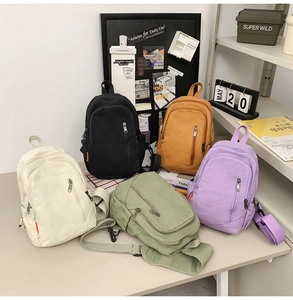 Detail view of colorful canvas crossbody bags with multi-zipper compartments and adjustable straps