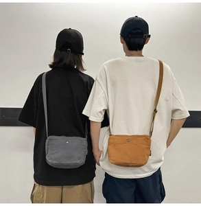 Detail showing grey and ginger yellow canvas crossbody bags worn by two models