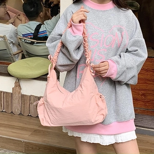 Pink nylon crossbody bag detail with ruffled scrunchie strap and drawstring accents