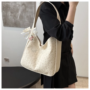 Detail of off-white lace hobo bag with floral embroidery and 3D flower bow decoration