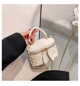 Close-up of a cream PU leather vanity bag with quilted texture and gold hardware