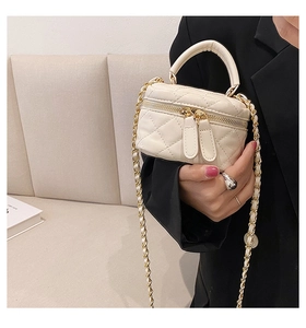 Detail of cream quilted PU leather mini crossbody bag with gold chain and dual zippers