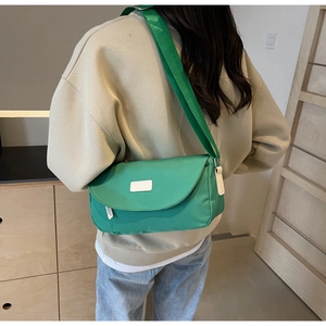 Detail der grünen Nylon-Umhängetasche mit verstellbarem Gurt und minimalistischem Patch