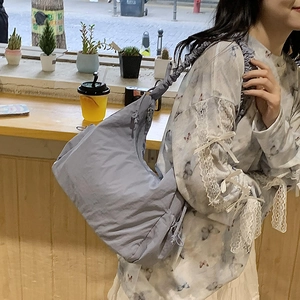 Detailed view of light blue nylon hobo bag with trendy pleated drawstring shoulder strap