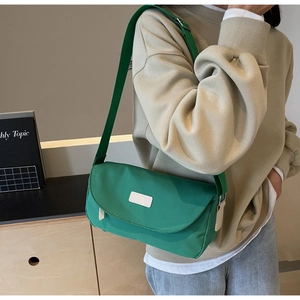 Detailansicht einer grünen Canvas-Umhängetasche mit minimalistischer Klappe und Akzent