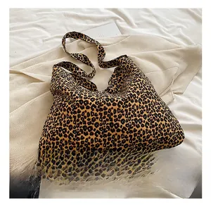 Close-up detail of leopard print tote bag with wide shoulder strap and fabric texture