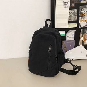 Minimalist black canvas crossbody bag with adjustable nylon strap and front zipper detail